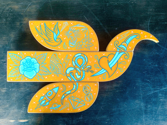 Decorative cutout with blue and orange designs on a dark surface